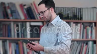 图书馆平板电脑上的年轻男<strong>教师视频</strong>会议